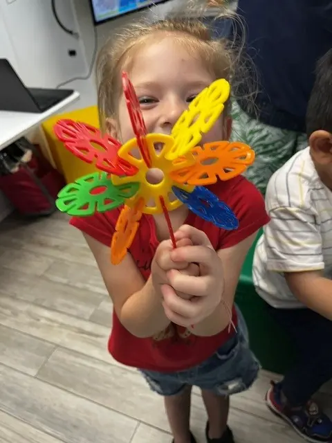 Child holding a colorful classroom spinner