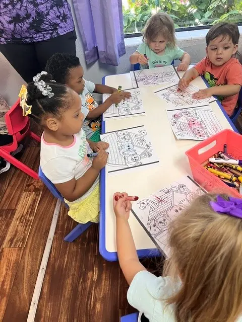Children coloring together at a classroom table