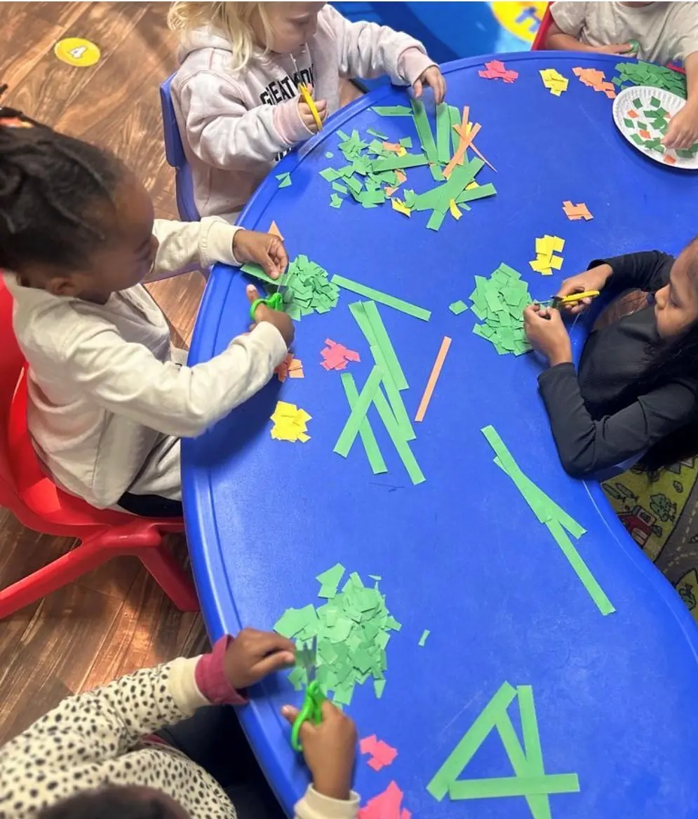 Children cutting colorful paper during a creative art activity