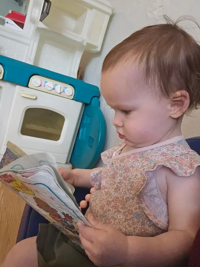 Infant looking through a picture book in the classroom