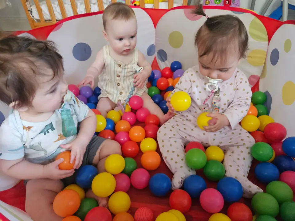 Infants exploring colorful balls together during supervised play