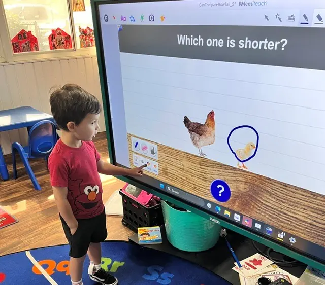 Child participating in an interactive classroom board lesson