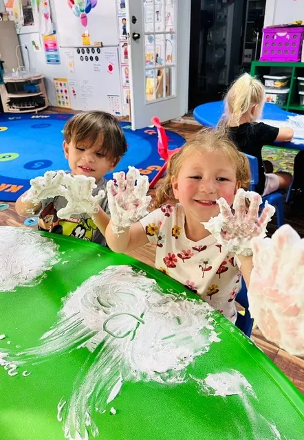 Children smiling during a messy sensory play activity