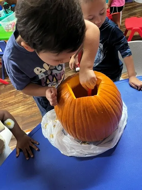 Children exploring a pumpkin during a classroom science activity