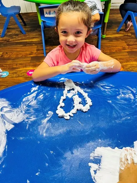 Child smiling during hands-on sensory foam play