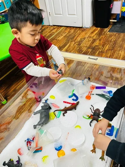 Child exploring animal figures during sensory play
